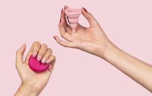 pink menstrual cups in hand