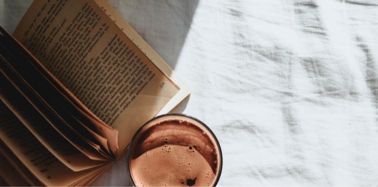 Coffee and book on bamboo sheets